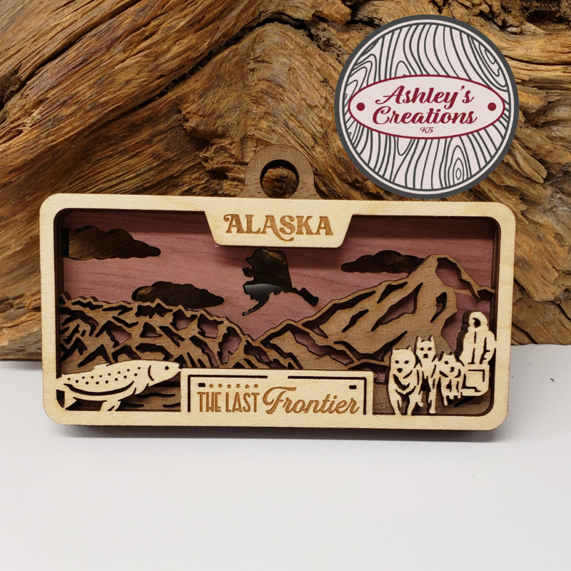 Wooden three layered ornament with Alaska design and 'Ashley's Creations' logo above