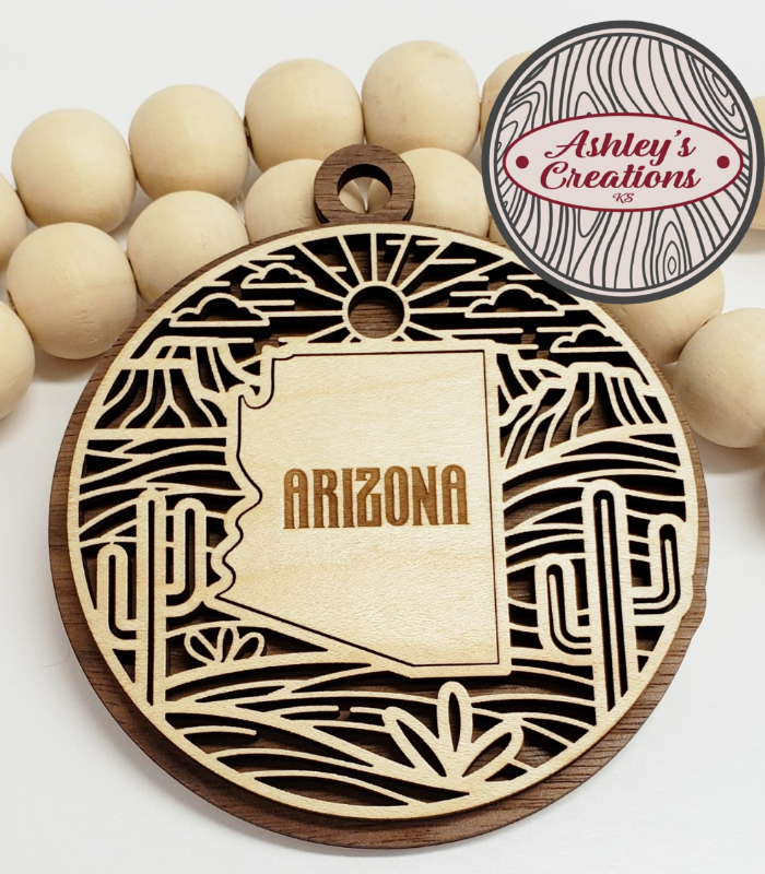 Wooden ornament with 'Arizona' engraving on a white background, branded 'Ashley's Creations'.