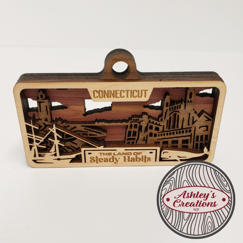 Wooden three layer license plate ornament with laser-cut design and 'Connecticut' text on a white background