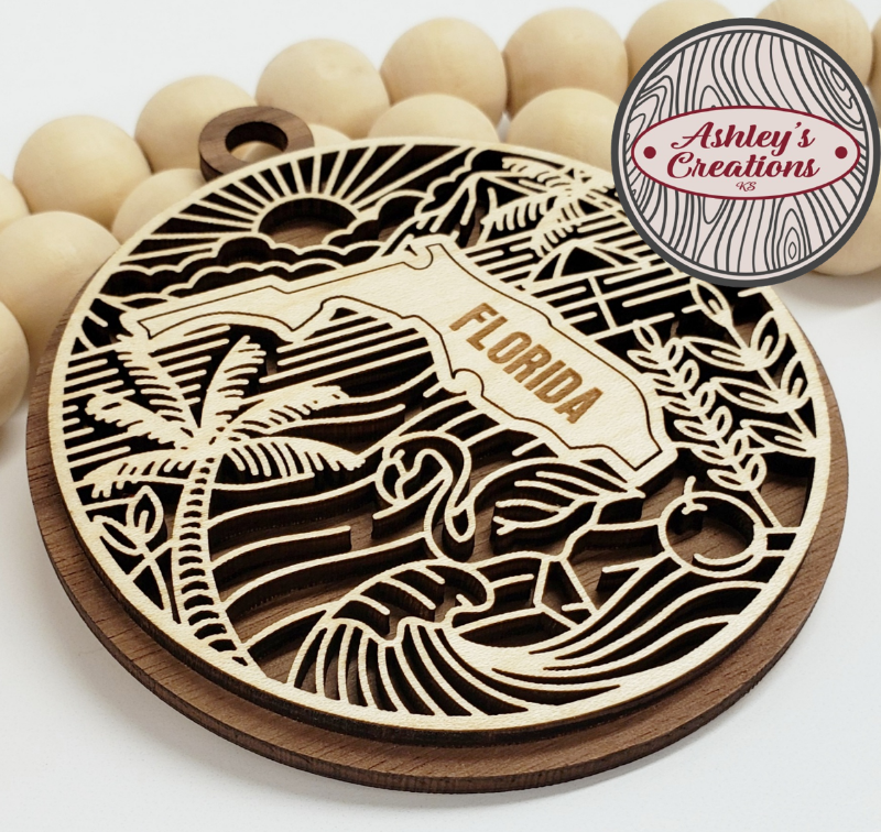 Wooden ornament with Florida design and palm trees, branded 'Ashley's Creations'.