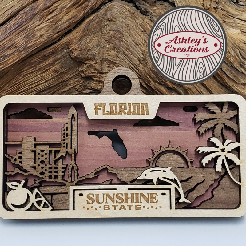 Wooden three layer license plate ornament with Florida-themed cutouts and 'Ashley's Creations' logo.