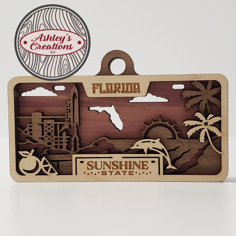 Wooden three layer license plate ornament with Florida-themed cutouts and 'Ashley's Creations' logo.