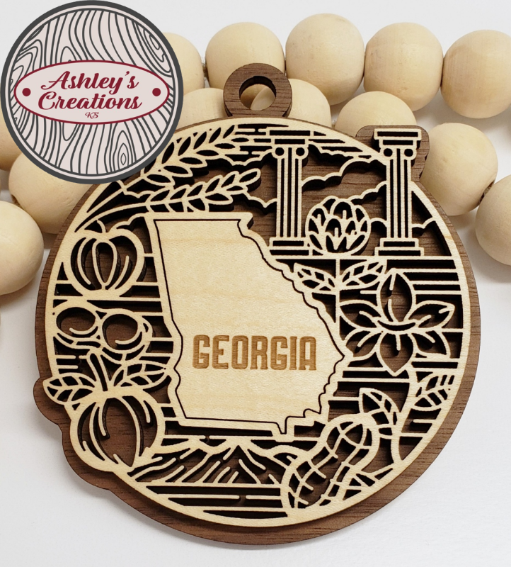 Wooden ornament with 'Georgia' design and 'Ashley's Creations' logo.