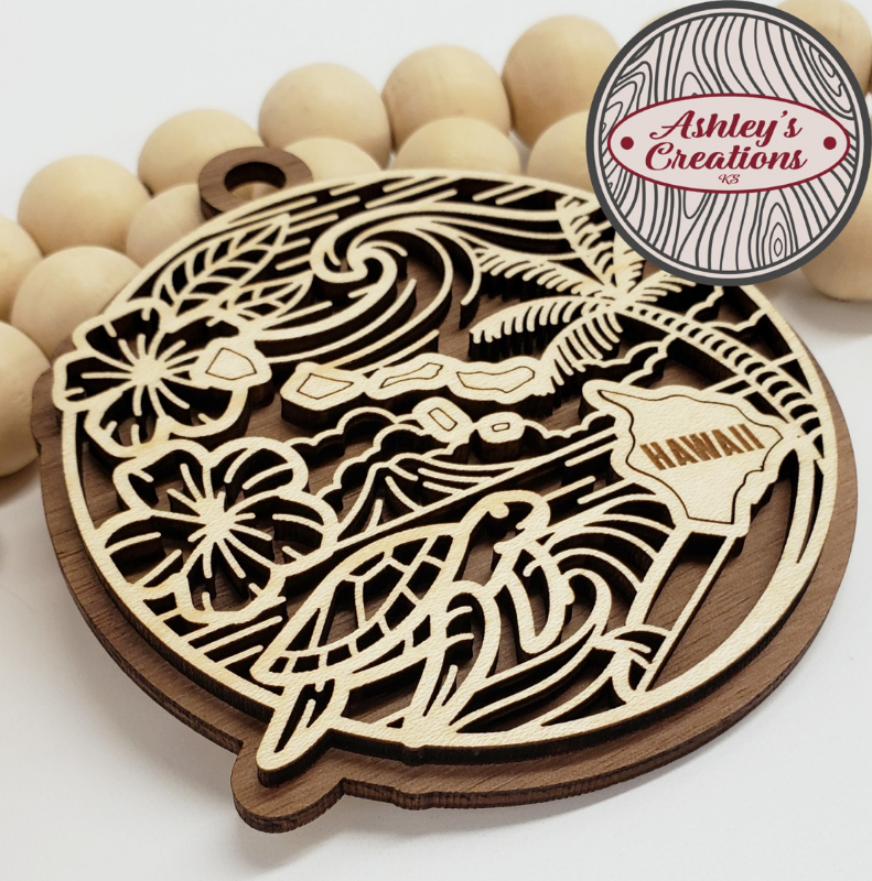 Wooden ornament with laser-cut design featuring a bird and 'Hawaii' text, surrounded by wooden beads.