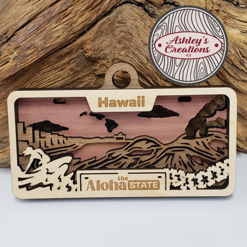 Wooden three layer license plate ornament with Hawaiian design and 'Ashley's Creations' logo.