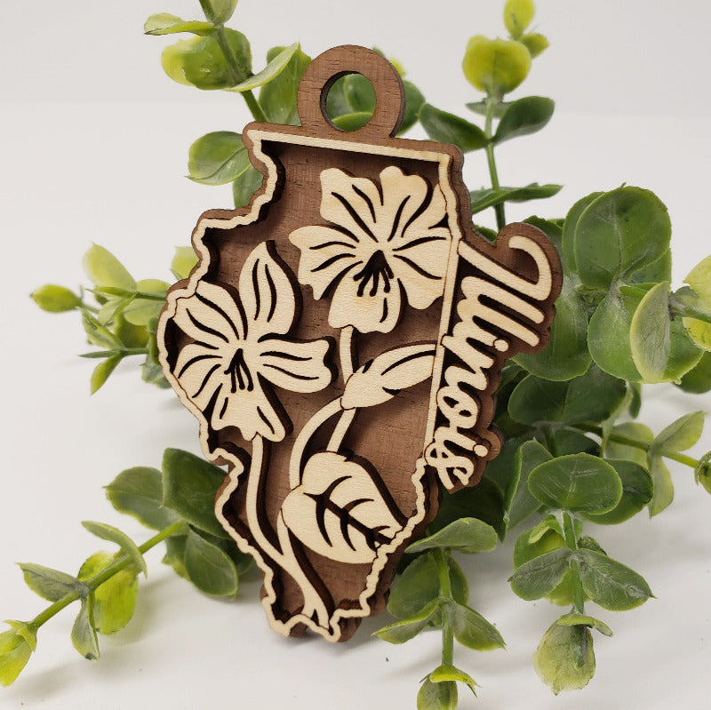 Two layer ornament in the shape of Illinois and featuring the state flower.