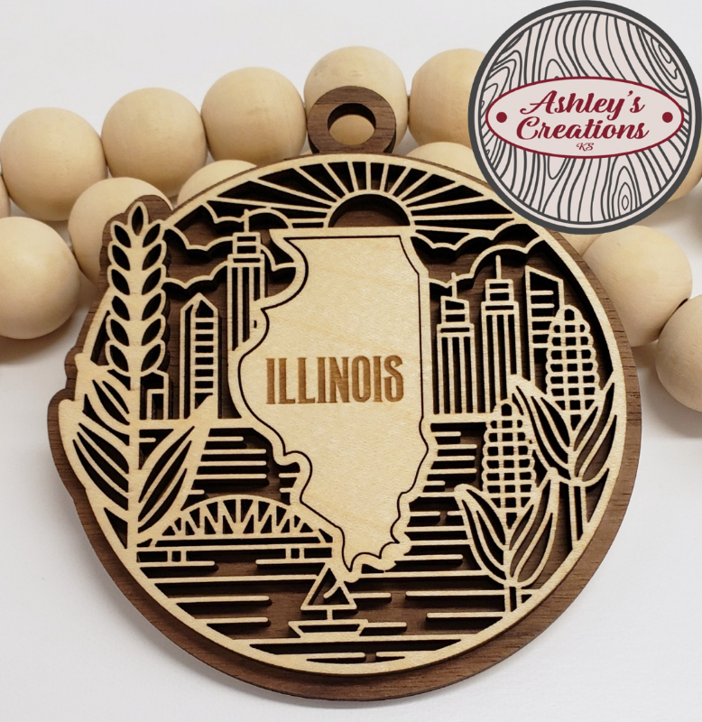 Wooden ornament with Illinois state design surrounded by wooden beads, branded 'Ashley's Creations'.