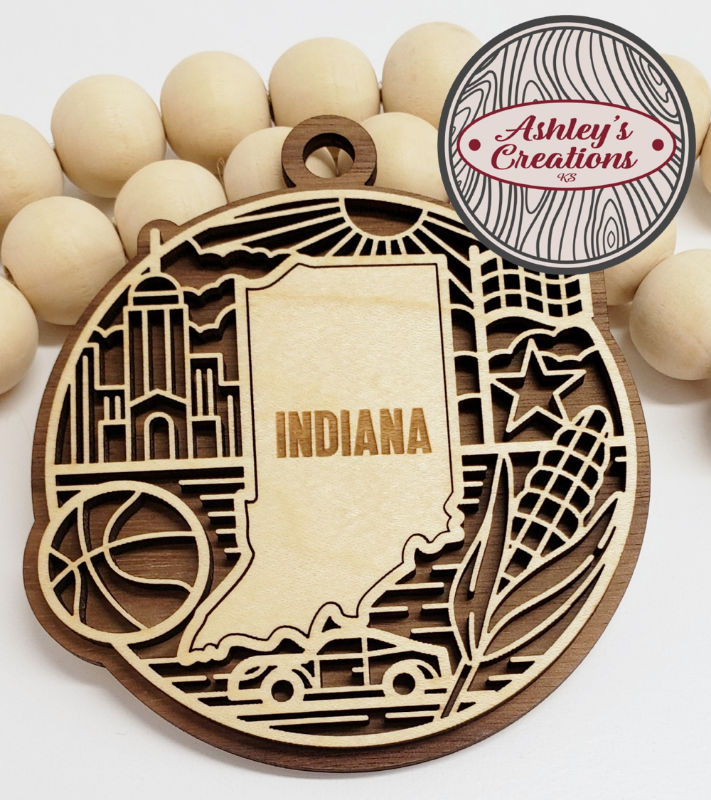 Wooden ornament shaped like the state of Indiana with decorative elements on a white background.