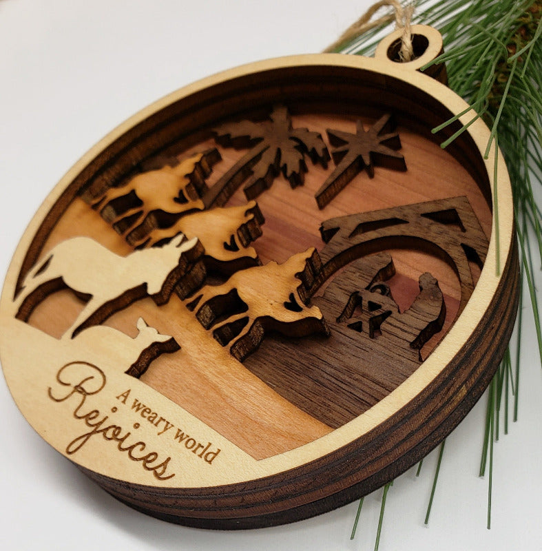 Wooden ornament with nativity scene design and 'A weary world rejoices' text, on a white background.