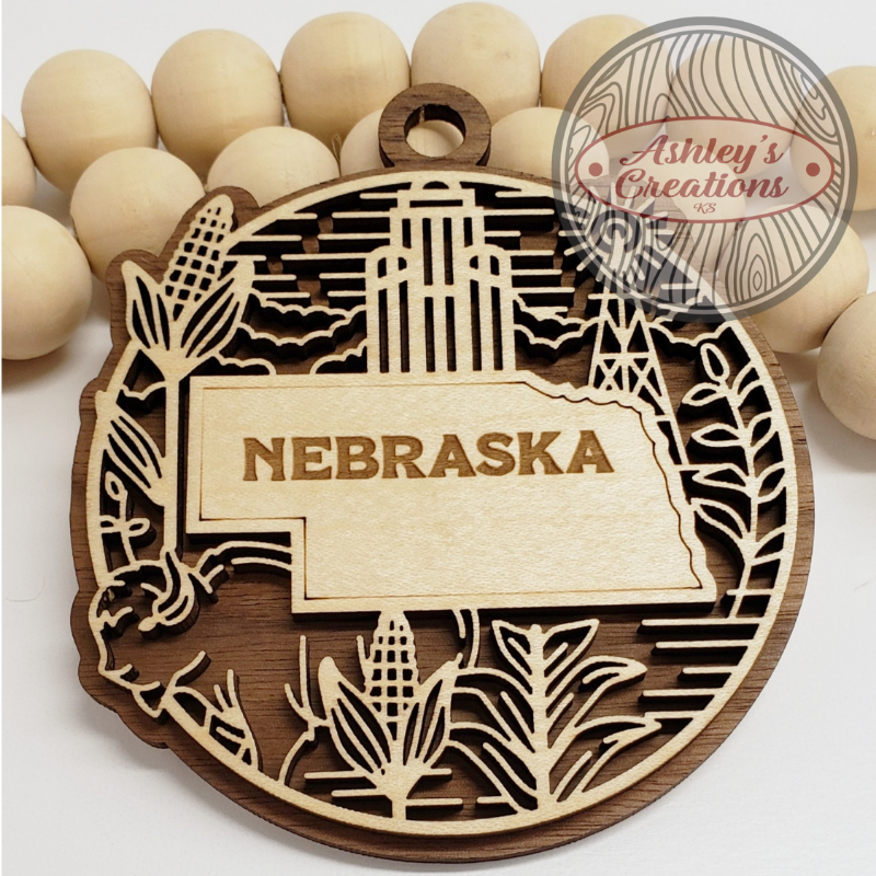 Wooden ornament with the state of Nebraska in the middle.