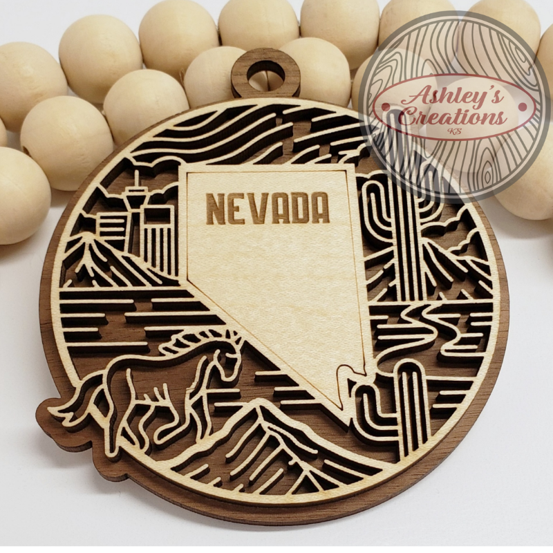 Wooden ornament with Nevada design and 'Ashley's Creations' branding.