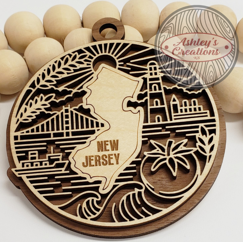 Wooden New Jersey-shaped ornament with laser-cut designs and 'Ashley's Creations' branding.
