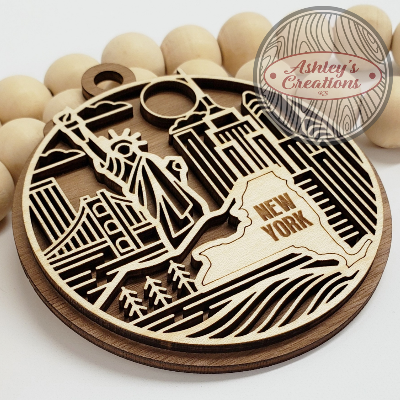 Wooden New York-themed ornament with 'Ashley's Creations' branding.