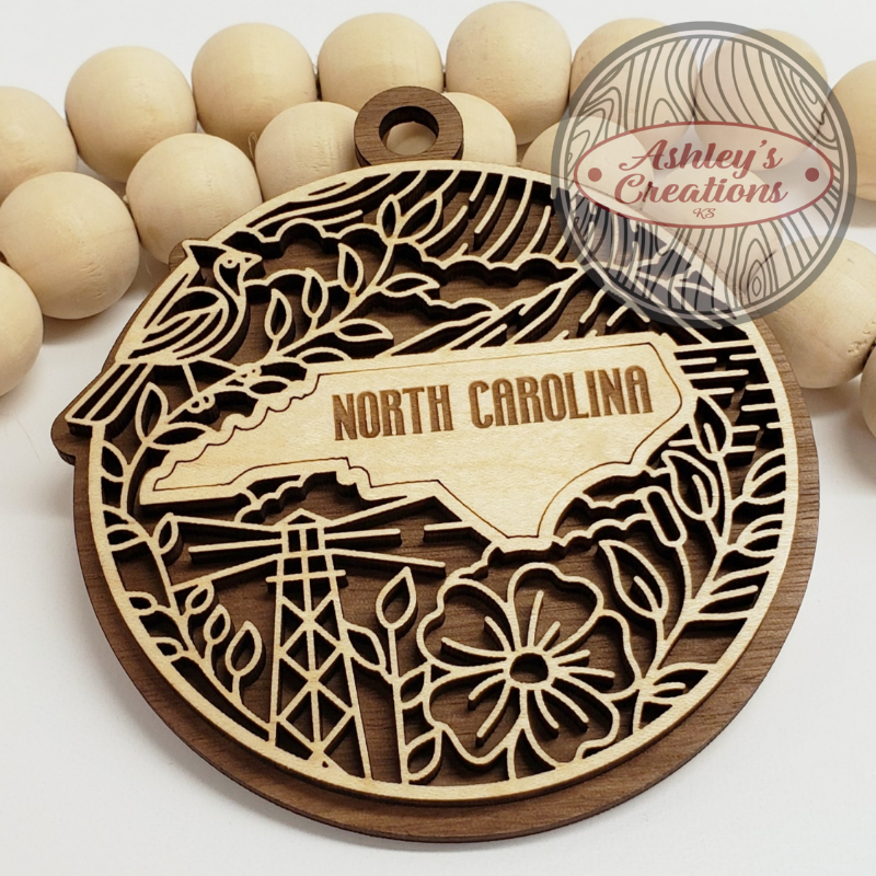 Wooden ornament with 'North Carolina' engraving, surrounded by wooden beads, on a white background.