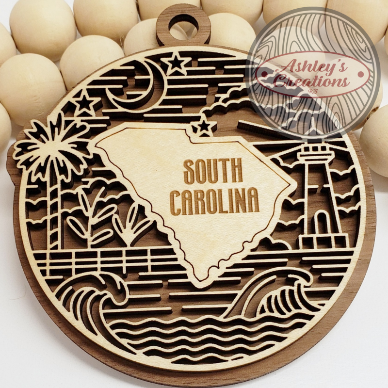 Wooden ornament with South Carolina design and 'Ashley's Creations' branding.