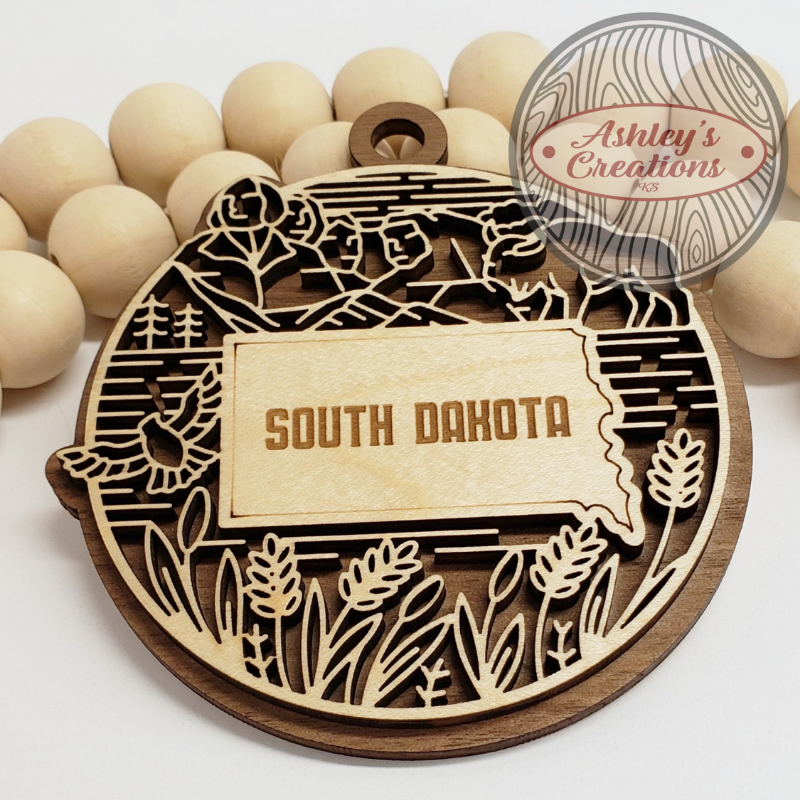 Wooden ornament with 'South Dakota' engraving on a white background