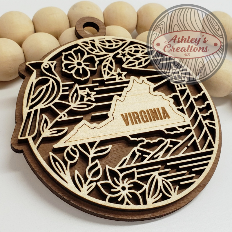 Wooden ornament with laser-cut design of Virginia and decorative elements, branded 'Ashley's Creations'.
