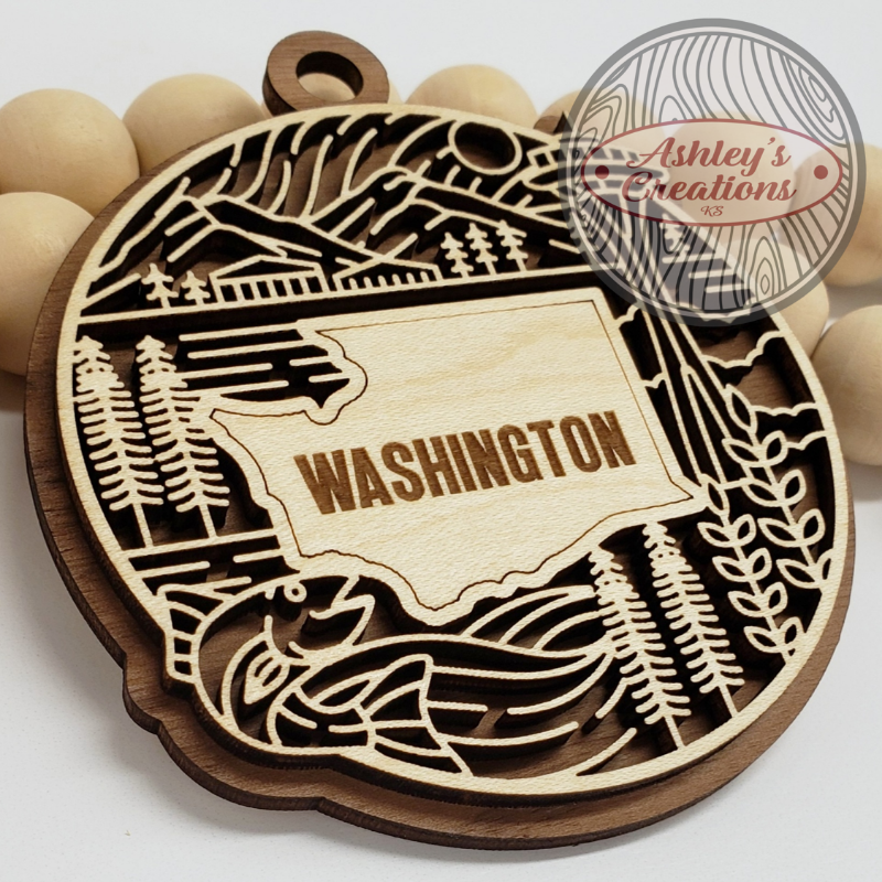 Wooden ornament with 'Washington' engraving and nature-themed design, branded 'Ashley's Creations'.