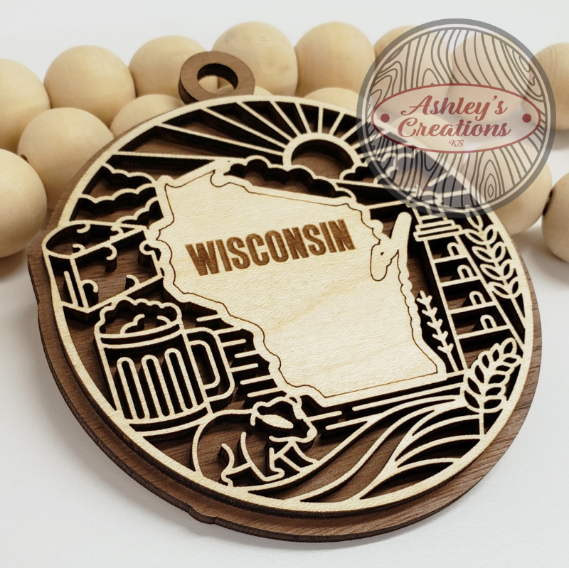 Wooden ornament with 'Wisconsin' engraving and beer mug design, branded 'Ashley's Creations'.